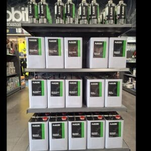 Display shelves in an automotive store showcasing Autobits branded products including thinners, brake cleaner, and panel wipes in metal containers.